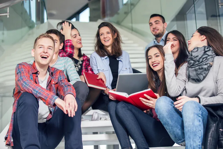 students-sitting-on-stairs-laughing-together