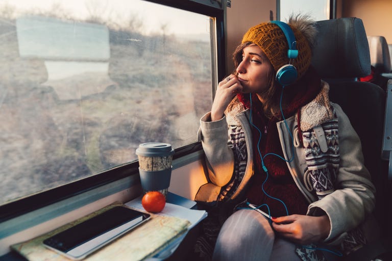 A female English language student looking out the window of a train while exploring the USA